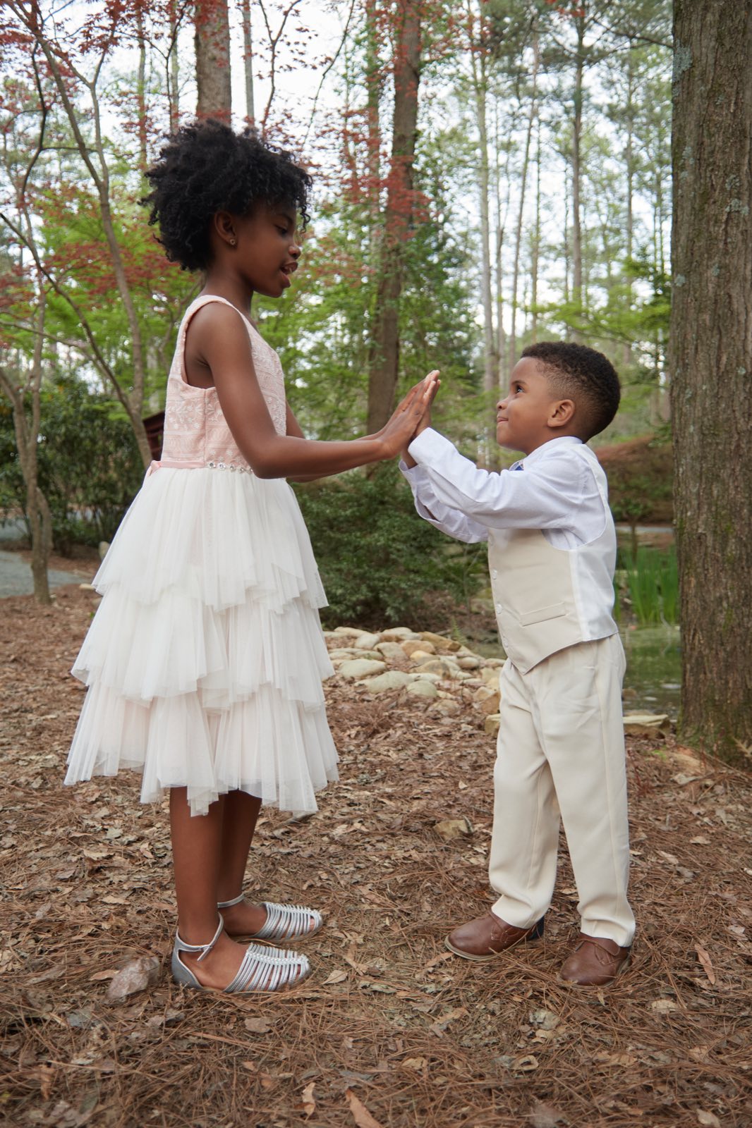 The two children reaching for each other's hands.